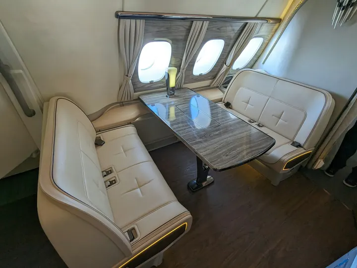 Club seating around a polished table in a compact aircraft cabin