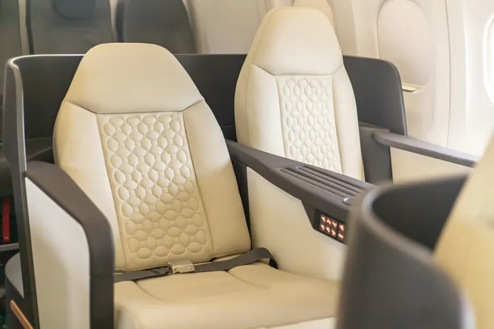 Two cream leather seats facing each other in a business jet cabin