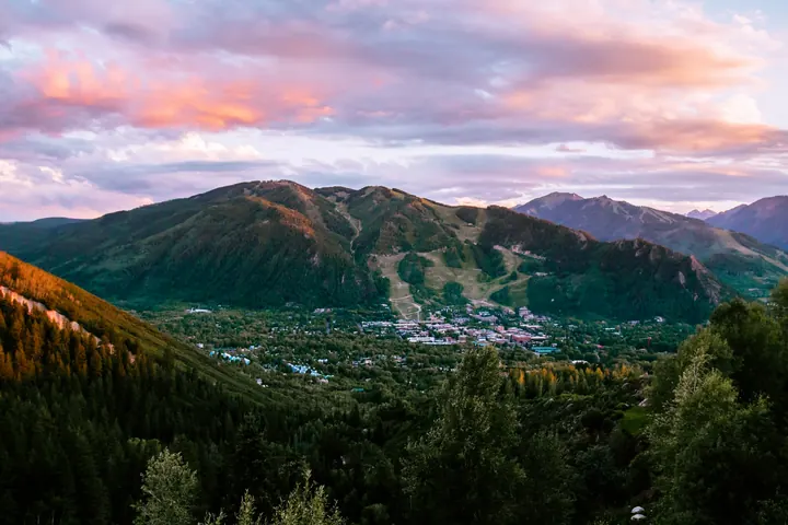 Aspen at sunset with the mountains glowing behind the town